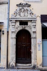 a building with a wooden door with a statue above it at Grande Rue * Place Stanislas in Nancy