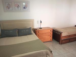 1 dormitorio con 2 camas y tocador de madera en Monoambientes Arandu en Federación