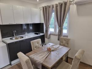 a kitchen with a table with chairs and a sink at Villa Park Ravne in Visoko