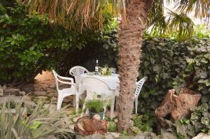 einen Tisch und Stühle in einem Palmengarten in der Unterkunft Apartment Ančica in Split