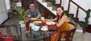 a man and woman sitting at a table eating food at Days Inn B/B in Kandy
