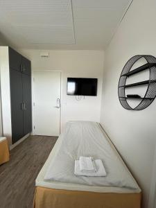 Dieses weiße Zimmer verfügt über ein Bett und einen TV. in der Unterkunft Wanha Tulli in Karesuvanto