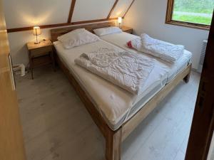 ein Schlafzimmer mit einem großen Bett mit zwei Kissen darauf in der Unterkunft Twistesee Ferienhaus 42 in Bad Arolsen
