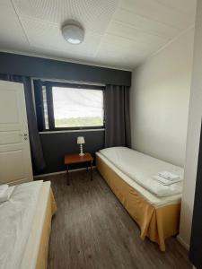 a small room with two beds and a window at Wanha Tulli in Karesuvanto
