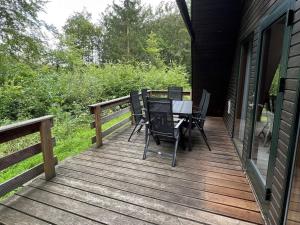 une terrasse en bois avec une table et des chaises. dans l'établissement Twistesee Ferienhaus 42, à Bad Arolsen