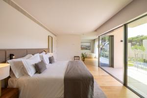 ein Schlafzimmer mit einem großen Bett und einem großen Fenster in der Unterkunft Marinha Prime in Cascais