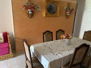 uma mesa com uma toalha de mesa branca e flores sobre ela em Ap6 em Saïdia