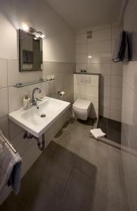 a bathroom with a sink and a toilet at Hotel Schmidt garni in Essen