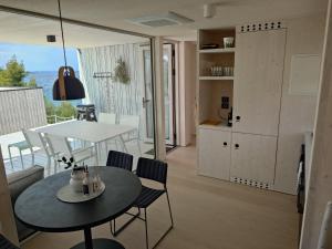 a kitchen and living room with a table and chairs at BUQEZ ECO RESORT - Beach Villas 2 and 8 - Seaview, new wifi! in Drage