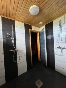 a bathroom with black and white tiles and a shower at Wanha Tulli in Karesuvanto