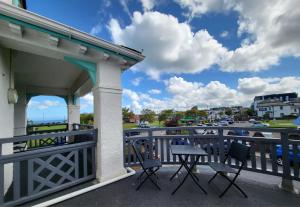 a balcony with chairs and a view of the water at Beach Hotel Torbay in Paignton