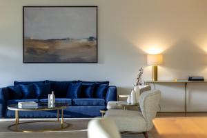 uma sala de estar com um sofá azul e uma mesa em Marinha Prime em Cascais
