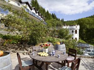 a table with fruit and a castle in the background at Hotel Haus Kylltal in Zendscheid