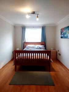 a bedroom with a wooden bed and a window at Seafront Holiday Home in Southend-on-Sea