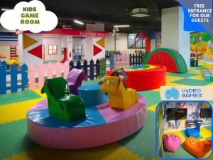 una sala de juegos para niños con un caballo de juguete y paseos en Caesar Resort & SPA en Trikomo