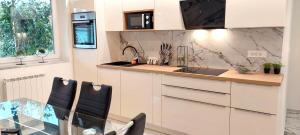uma cozinha com armários brancos e uma mesa de vidro em ISTRIANA em Koper