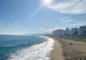 uma praia com edifícios e o oceano num dia ensolarado em Nubes Hotel em Viña del Mar