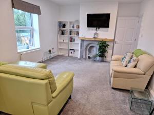 a living room with two couches and a fireplace at Spacious, modern first floor flat near beach and ferry in East Cowes