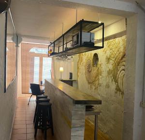 eine Küche mit einer Bar mit Hockern und einer Mikrowelle in der Unterkunft Sitgesnextdoor in Sitges