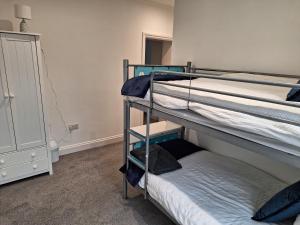 a bedroom with two bunk beds and a small bed at Spacious, modern first floor flat near beach and ferry in East Cowes