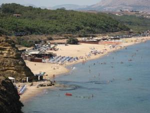 una spiaggia con un gruppo di persone in acqua di Hotel Costa Azul a Balestrate