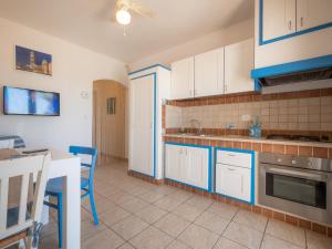 a kitchen with blue and white cabinets and a table at Residence Salento Fronte Mare in Torre San Giovanni Ugento +25 photos
