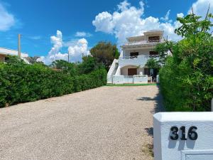 a white house with a number on the driveway at Residence Salento Fronte Mare - Coste del Sud it in Torre San Giovanni Ugento +40 photos