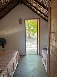 a room with two beds and a large window at Hausatins in Atins