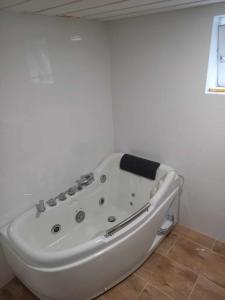 Hytte Sørlandet med spa في Froland Verk: حوض استحمام أبيض في غرفة بيضاء