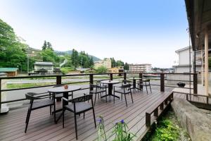 a deck with tables and chairs on top of a building at Wafu-no-Yado MASUYA in Yamanouchi