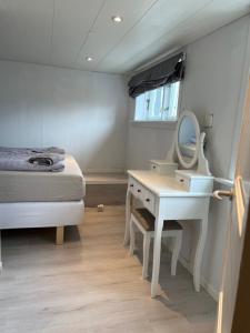1 dormitorio con cama, tocador y espejo en Cory & Torfinn House, en Sørvágur
