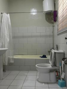 ein Badezimmer mit einem WC und einer Badewanne in der Unterkunft Blissful Lodgings in Jos