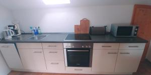 a kitchen with a counter top with a sink and a microwave at Ferienwohnung Bergglück in Lenggries