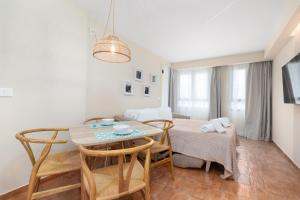 Una cocina y un comedor con mesa y sillas. en Apartamentos Las Ciencias I, en Valencia