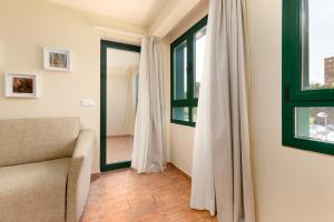 Una sala de estar con un sofá y una ventana. en Apartamentos Las Ciencias I, en Valencia 43 fotos más