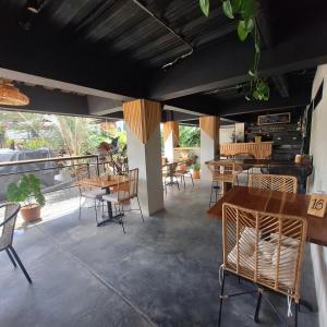 un restaurant avec des tables et des chaises en bois et une terrasse dans l'établissement Balcones del Ayer, à Salento