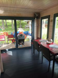 a screened in porch with tables and chairs and a grill at AQUA Bērzgale in Bērzgale