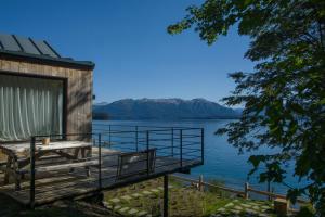 a house with a dock on the water at Correntoso TownHouses in Villa La Angostura
