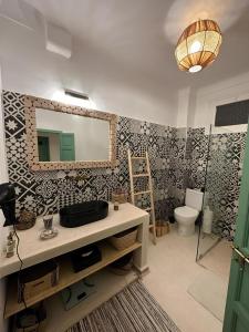 a bathroom with a mirror and a sink and a toilet at Dar Julia in Marrakesh
