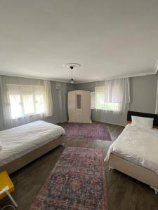 a bedroom with two beds and two rugs at Triplex house near the airport in Arnavutköy