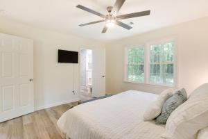 a white bedroom with a bed and a ceiling fan at Northport Game Day Getaway 5 Mi to University! in Tuscaloosa