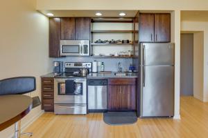 a kitchen with stainless steel appliances and wooden cabinets at Centrally Located Harrisburg Studio Near Downtown! in Harrisburg