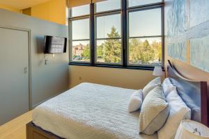 um quarto com uma cama, uma televisão e janelas em Centrally Located Harrisburg Studio Near Downtown! em Harrisburg