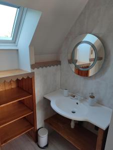 une salle de bain avec un lavabo et un miroir dans l'établissement Maison entre terre et mer ***, à Concarneau