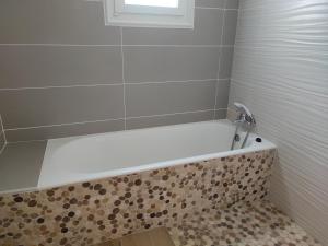 La salle de bains est pourvue d'une baignoire et d'une fenêtre. dans l'établissement Maison entre terre et mer ***, à Concarneau 2 autres photos