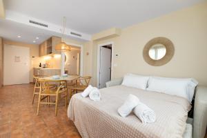 Un dormitorio con una cama y una mesa en una habitación. en Apartamentos Las Ciencias S, en Valencia