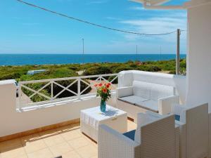 a balcony with a vase of flowers on a table at Residence Salento Fronte Mare in Torre San Giovanni Ugento