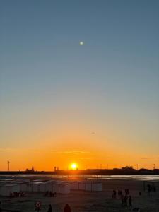 people walking on the beach at sunset at Hip en lichtrijk appartement vlakbij het strand in Knokke-Heist