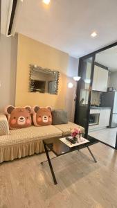 a living room with a couch with two teddy bears on it at The base Central Pattaya 903 by Numam in Pattaya Central