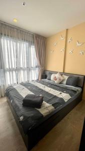 a bedroom with a bed with birds on the wall at The base Central Pattaya 903 by Numam in Pattaya Central